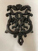 ~ Vintage Black Cast Iron Trivet Hot Plate Ornate Angels Cherubs Pattern Footed