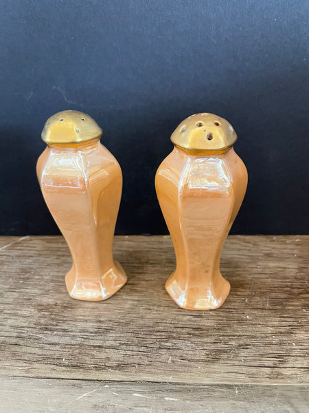a** Pair of Gold Iridescent Salt and Pepper Shakers 3” H x 2” Diameter Gold Tops